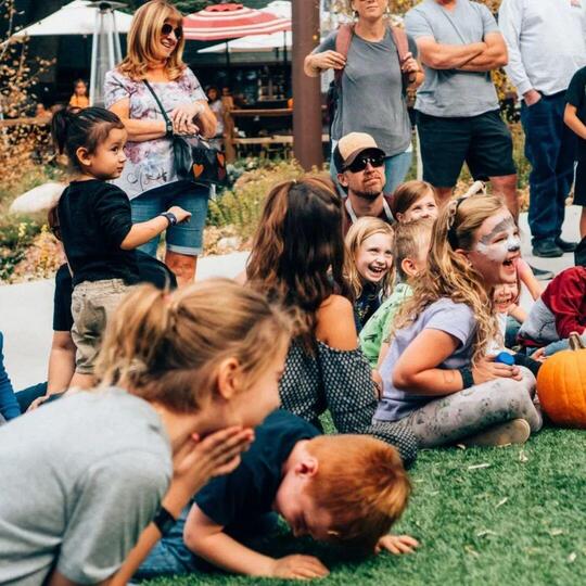 A crowd of kids and parents laughing at the show