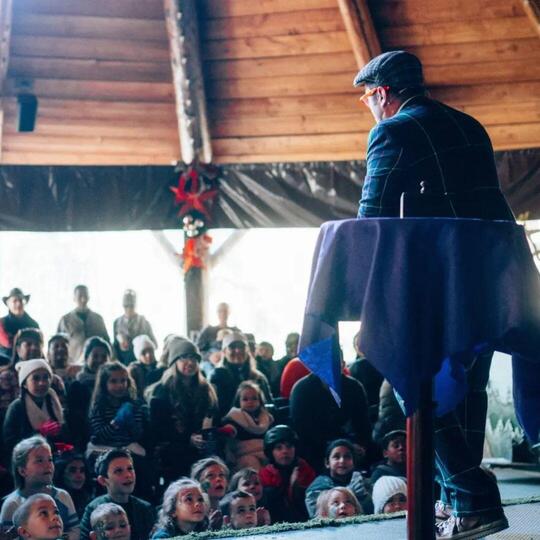 Wacko performing on stage for a large group of kids
